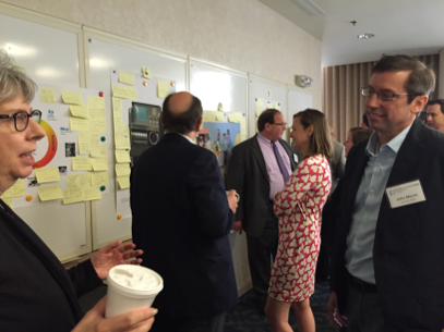 Photo showing SOT attendees contributing throughts and ideas to posters on post-it notes.